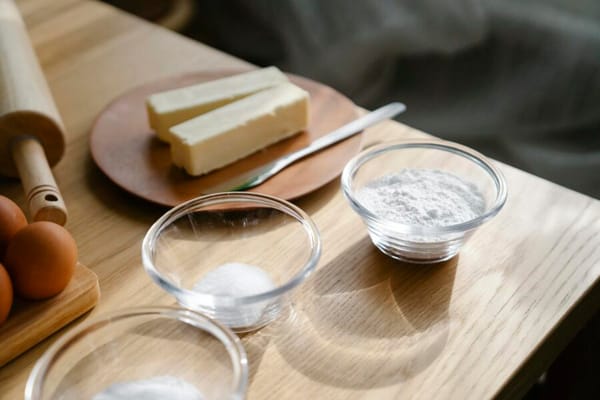 Close-up of baking ingredients on a wooden table with natural lighting.
